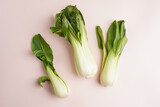 Chinese cabbage pak choi on light pink surface, top view