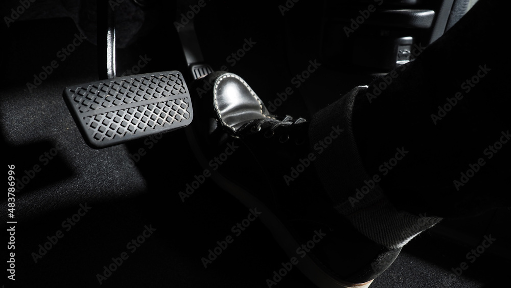 Accelerate and Brake. Foot pressing foot pedal of a car to drive ahead