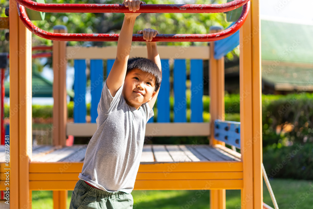 Fototapeta premium Asian kid plays in the outdoor playground. Concept of learning outdoor and happiness