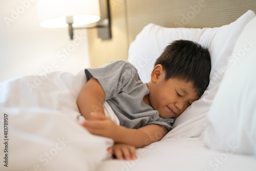 Asian boy just wake up on the bed at the hotel