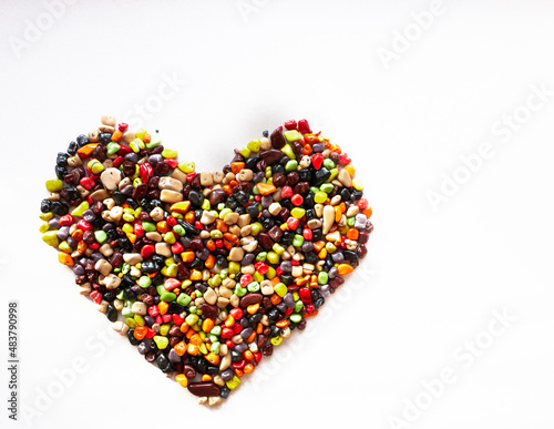 Heart lined with multi-colored candy sea stones on a white background