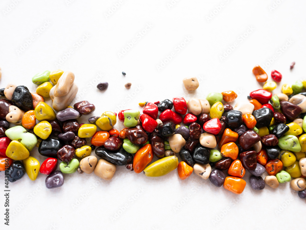 Candy multi-colored sea stones on a white background. Place for text Candy multi-colored sea stones on a white background. Place for text