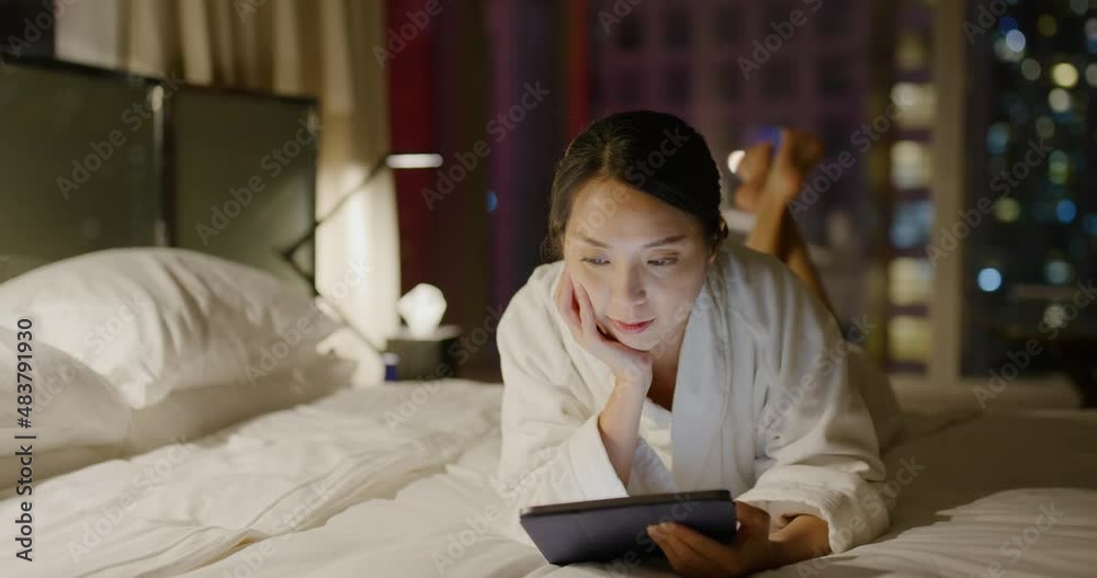 Woman look at the tablet computer on bed at night Woman look at the tablet computer on bed at night