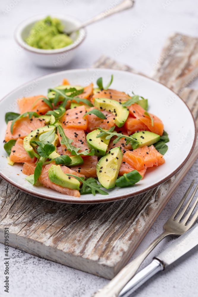 Fresh salmon salad with avocado, for keto and low carb diet. Rusty background, top view, copy space. Fresh salmon salad with avocado, for keto and low carb diet. Rusty background, top view, copy space.