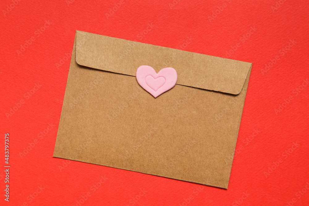 Empty brown craft envelope, sticker heart on red background. top view, copy space. Greeting card mockup Valentines Day Empty brown craft envelope, sticker heart on red background. top view, copy space. Greeting card mockup Valentines Day