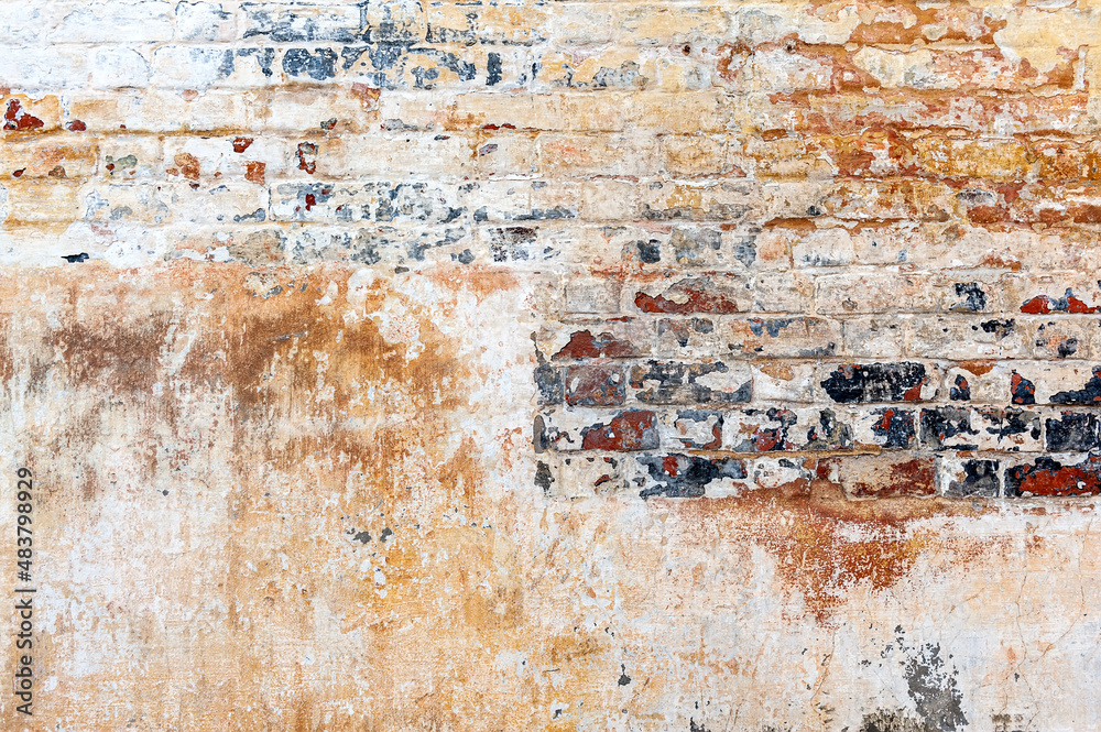 Old brick wall with peeling plaster, grunge background