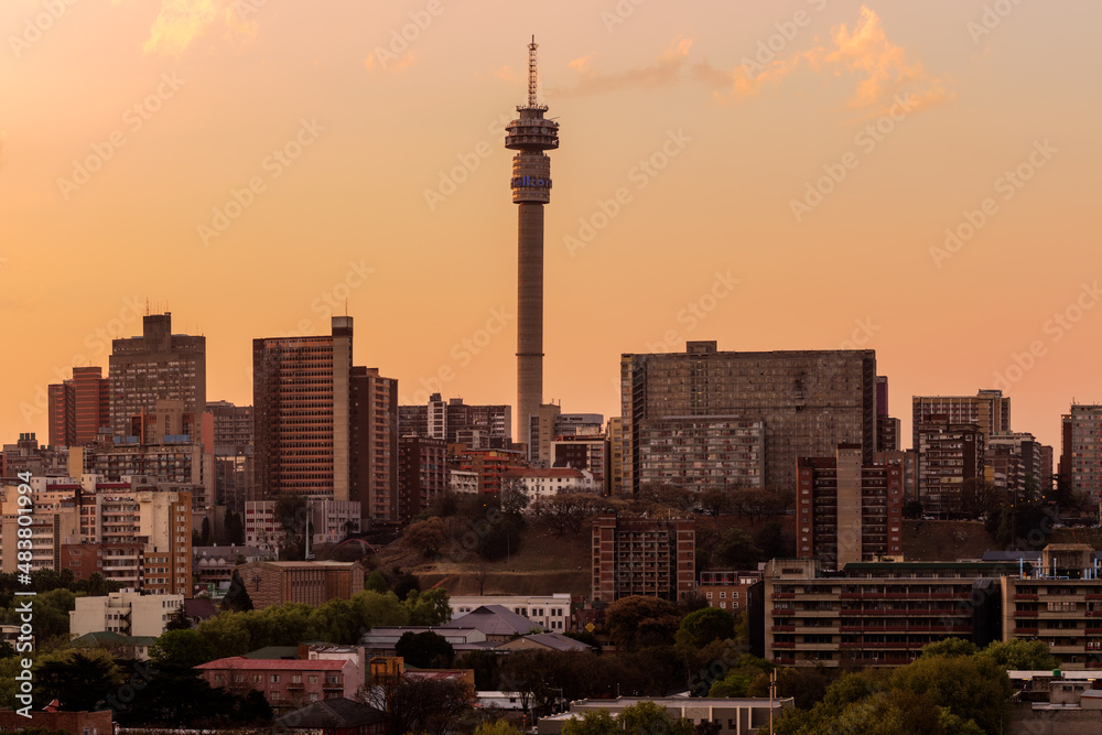 Obraz premium A horizontal panoramic cityscape taken at sunset, of the central business district of the city of Johannesburg, South Africa