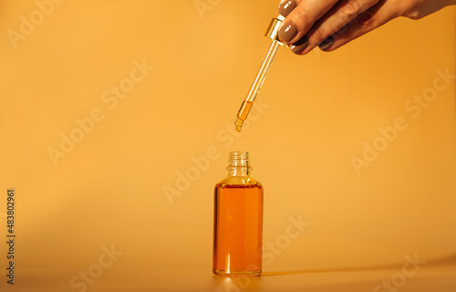 Drops of facial serum with pipette on glass