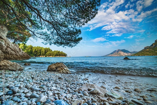 Wybrzeże i morze Chorwacji z kamienną plażą i niebieskim niebem z białymi chmurami