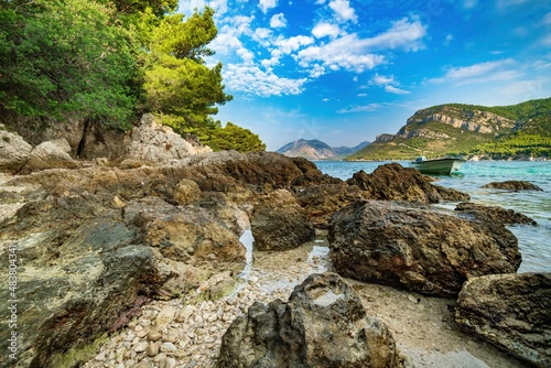 Fototapeta Naklejka Na Ścianę i Meble -  Wybrzeże i morze Chorwacji z kamienną plażą i niebieskim niebem z białymi chmurami