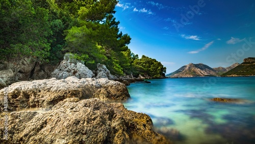 Fototapeta Naklejka Na Ścianę i Meble -  Wybrzeże i morze Chorwacji z kamienną plażą i niebieskim niebem z białymi chmurami