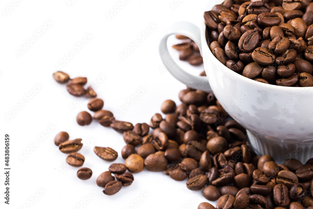 Cup filled with a roasted coffee beans on white background Cup filled with a roasted coffee beans on white background