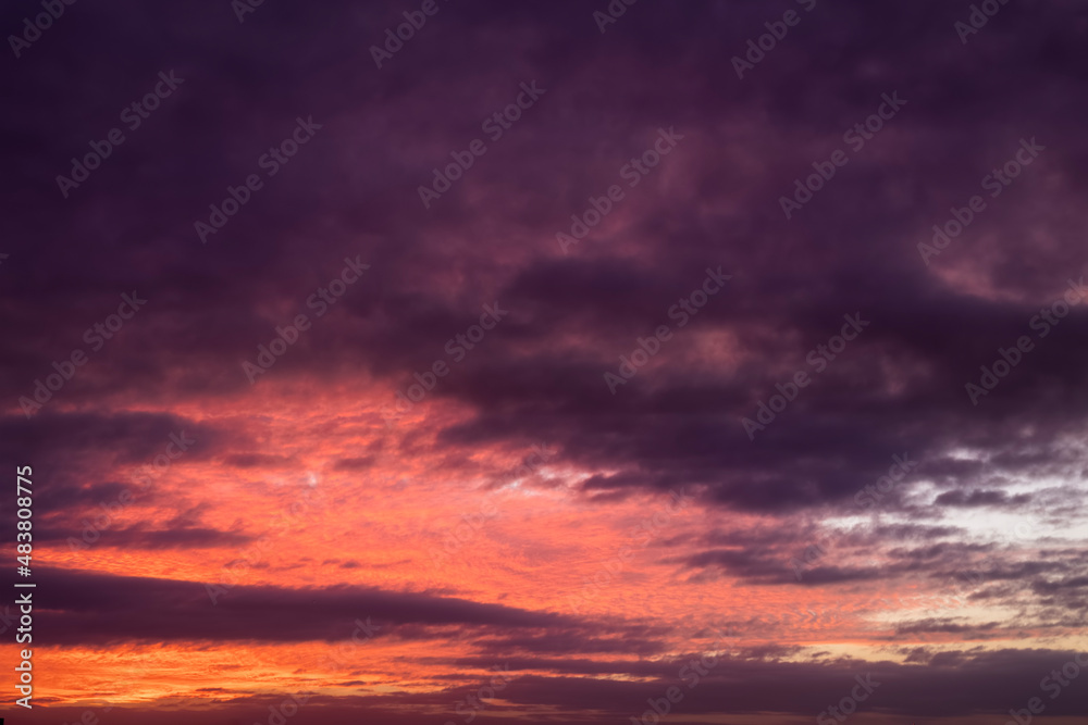 A vibrant evening sky with clouds and purple colors as background or texture