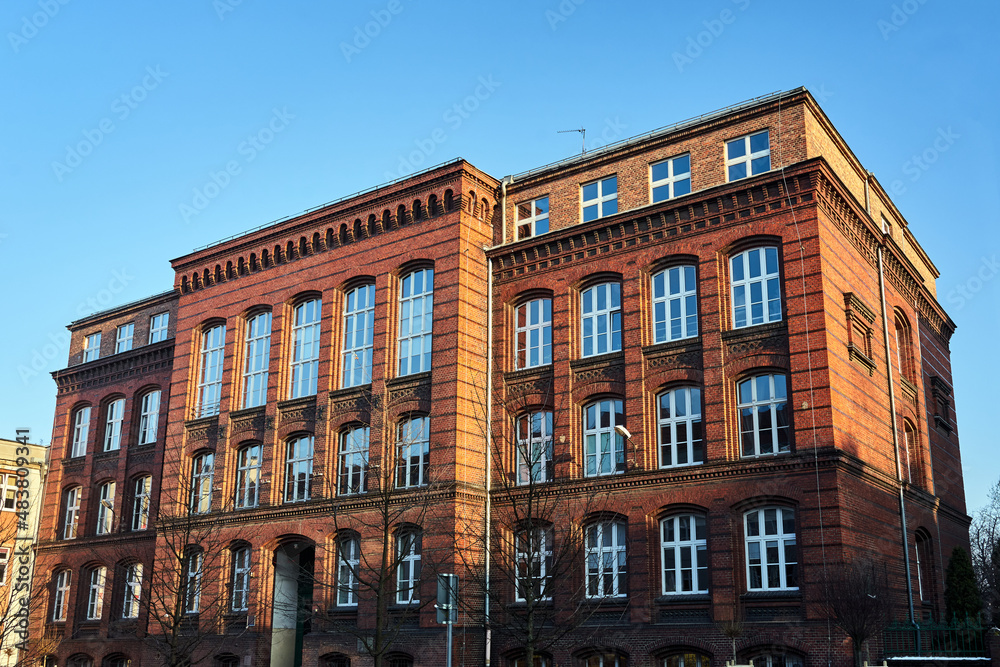 facades of a historic red brick tenement house in the city of Poznan, Poland
