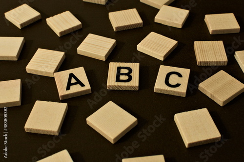 Scattered wooden squares. in the middle the word abc symbolizing for example education, letters or the alphabet