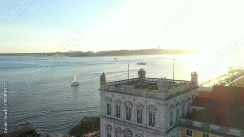 Aerial drone view of the Augusta Street Arch from Commerce Square in Lisbon, Portugal. Winter sunset. Tagus River and bridge in the background. (ID: 483810377)
