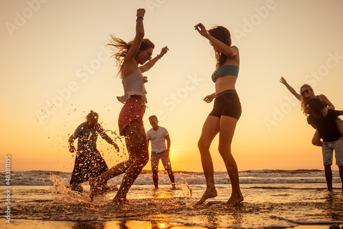 multicultural multinational happy people running into the sun carefree and happiness, vacation on sea