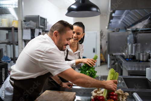 Chefs preparing vegetables for cutting in commercial kitchen.