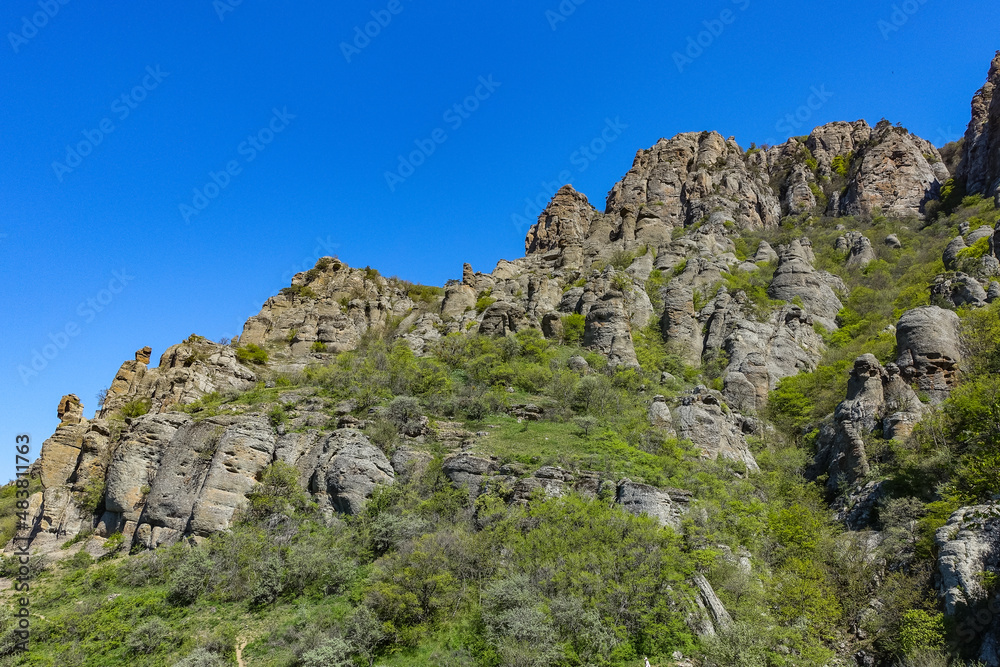 Ancient limestone high mountains of rounded shape in the air haze. The Valley of Ghosts. Demerdzhi. Crimea.