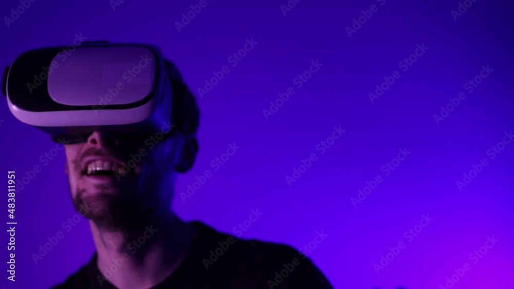 Man in metaverse using VR virtual reality glasses. Futuristic universe games and future in digital technology. Entreatment and NFT in neon colorful space. Happy male. Slow motion video in 3d cyber. Man in metaverse using VR virtual reality glasses. Futuristic universe games and future in digital technology. Entreatment and NFT in neon colorful space. Happy male. Slow motion video in 3d cyber.