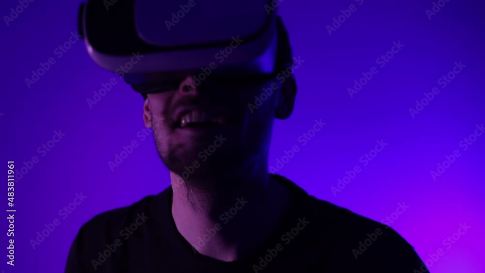 Man in metaverse using VR virtual reality glasses. Futuristic universe games and future in digital technology. Entreatment and NFT in neon colorful space. Happy male. Slow motion video in 3d cyber. Man in metaverse using VR virtual reality glasses. Futuristic universe games and future in digital technology. Entreatment and NFT in neon colorful space. Happy male. Slow motion video in 3d cyber.