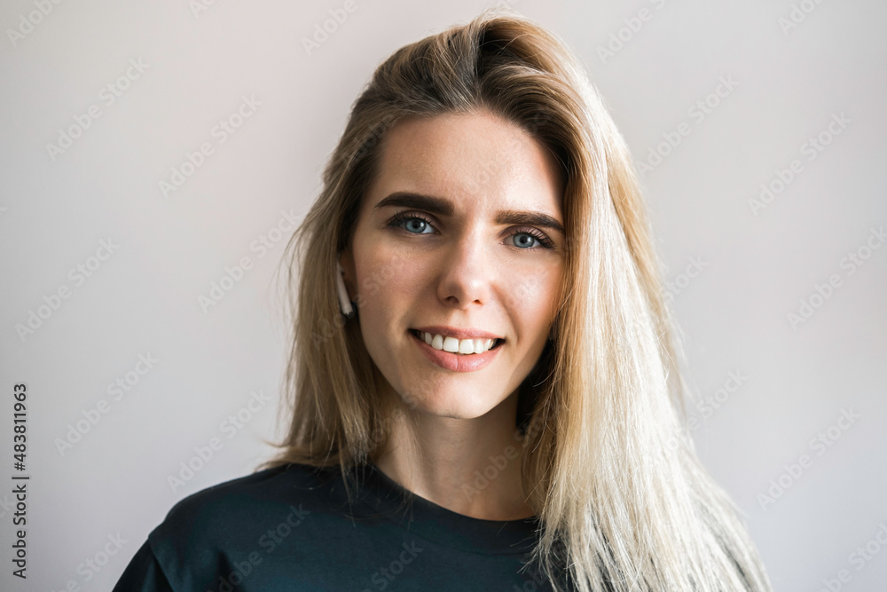 Portrait of a woman. Style. A beautiful blue-eyed girl smiles at the camera on a light background Portrait of a woman. Style. A beautiful blue-eyed girl smiles at the camera on a light background