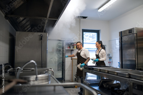 Chef and cook working on their dishes indoors in restaurant kitchen.