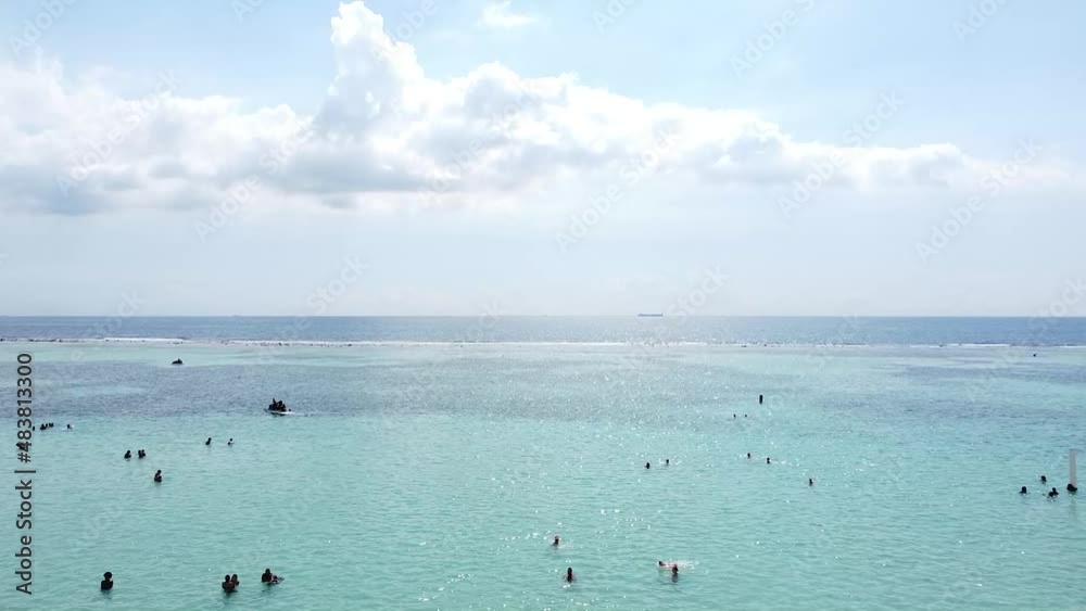 toma de drone acercandose a grupo de turistas disfrutando hermosa playa en boca chica republica dominicana. toma de drone acercandose a grupo de turistas disfrutando hermosa playa en boca chica republica dominicana.