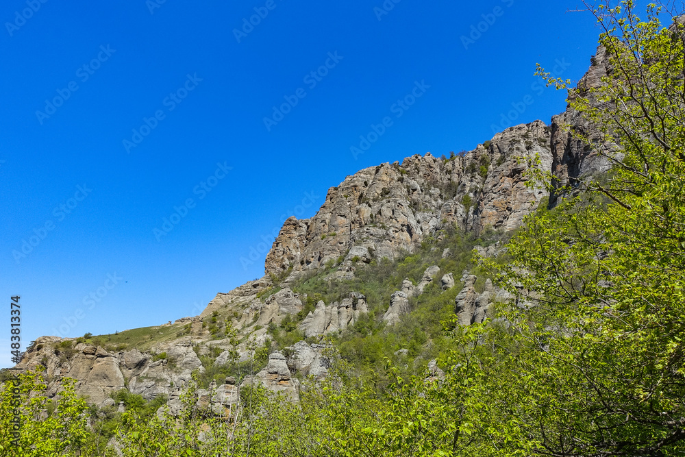 Ancient limestone high mountains of rounded shape in the air haze. The Valley of Ghosts. Demerdzhi. Crimea.