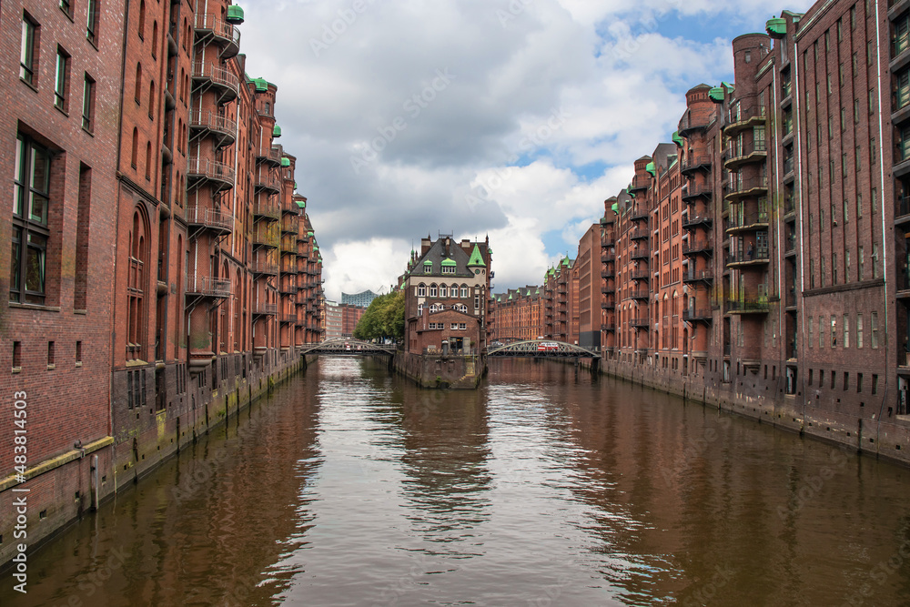Hamburg, German. View of famous Speicherstadt warehouse district. Old brick building, river canal of Hafencity quarter. Hamburg skyline.