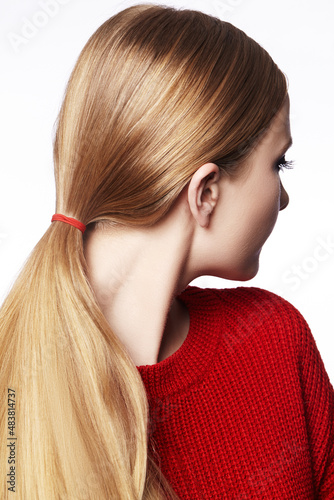 Woman with Straight Blond Hair  Tied in Ponytail  Wearing Red Knitted Pullover. Beautiful Gold Hair in Pony Tail