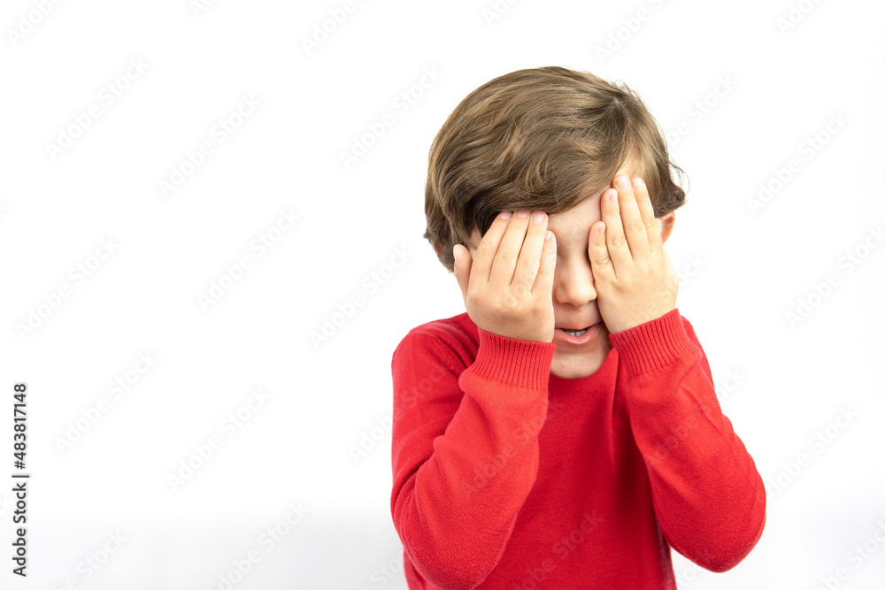 Unhappy little boy Covering Face With Hands Against White Background. Unhappy little boy Covering Face With Hands Against White Background.
