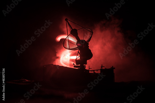 Silhouettes of satellite dishes or radio antennas against night sky. Space observatory or Air defence radar over dramatic night sky. Creative artwork decoration. Selective focus