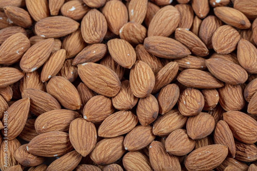 Peeled almonds close-up. For vegetarians. Almonds in wooden bowl on white background. Peeled almonds close-up. For vegetarians. Almonds in wooden bowl on white background.