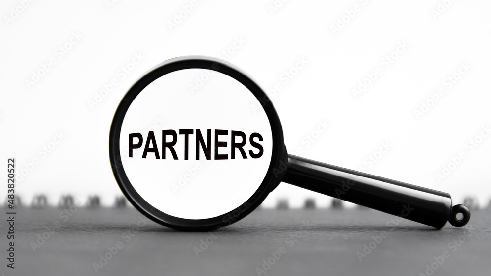 look closely and Partners with a magnifying glass. business concept. magnifying glass on the white background look closely and Partners with a magnifying glass. business concept. magnifying glass on the white background