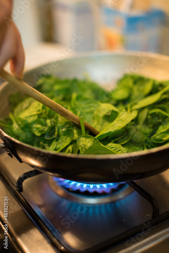 Obraz na płótnie Spinach in a pot with lit fire w salonie