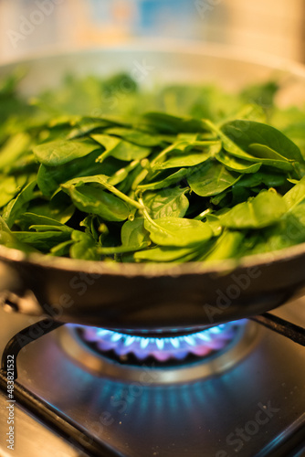 Obraz na płótnie Spinach in a pot with lit fire w salonie