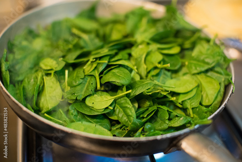 Obraz na płótnie Spinach in a pot with lit fire w salonie