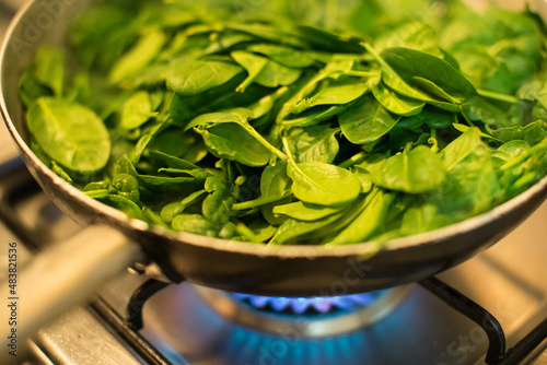 Obraz na płótnie Spinach in a pot with lit fire w salonie