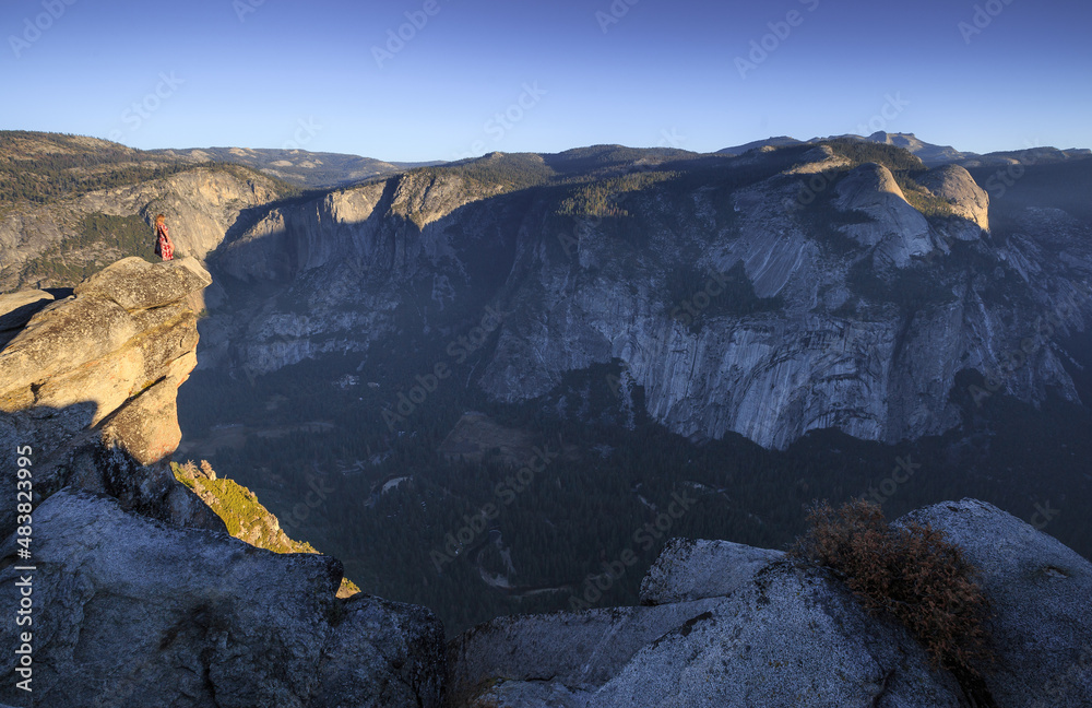 Beautiful view of Yosemite National Park into the valley during sunrise with a girl on the lookout