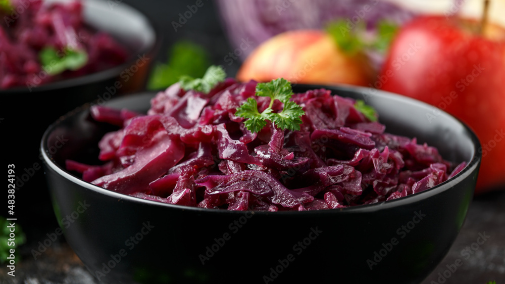 Braised Red Cabbage with apples and redcurrant in black bowl Braised Red Cabbage with apples and redcurrant in black bowl