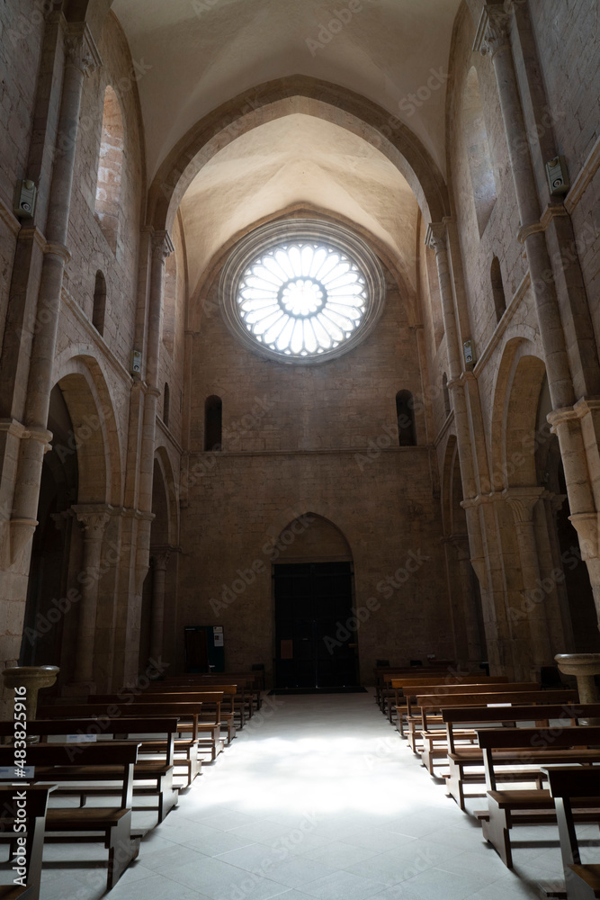 interno di abbazia con suggestivo riflesso sul pavimento in basso del rosone in alto con 24 colonnine , stile architettonico gotico cistercense , senso di elevazione verso l ' alto