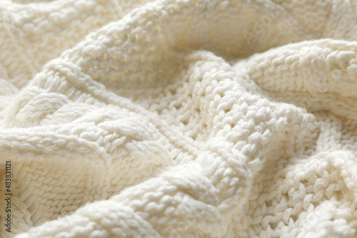 White knitted fabric with beautiful pattern as background, closeup