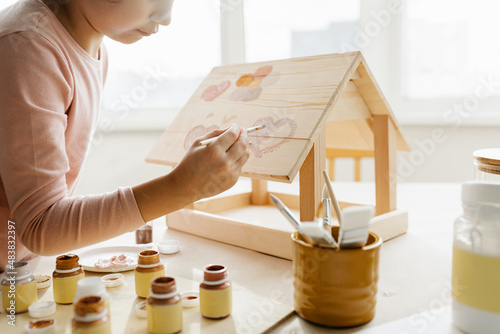Canvastavla Caucasian girl kid colors wooden bird feeder, winter bird care and children's creativity at home