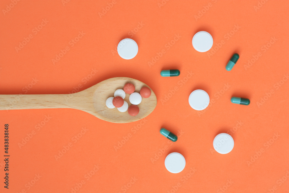 Φωτογραφία color medical capsules on wooden spoon