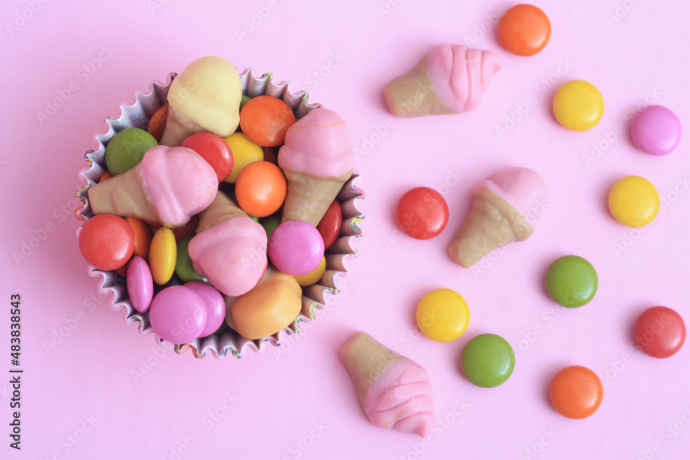 Bright multi colour chocolate gemes on pink background Bright multi colour chocolate gemes on pink background