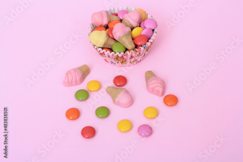 Bright multi colour chocolate gemes on pink background © Burcu Saritas