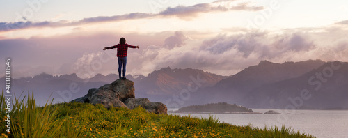 Adventurous Woman with hands out standing on a rock. Dramatic Sunrise Sky. 3d rendering. Background Mountain Landscape from Pacific Coast of Alaska, USA. © edb3_16