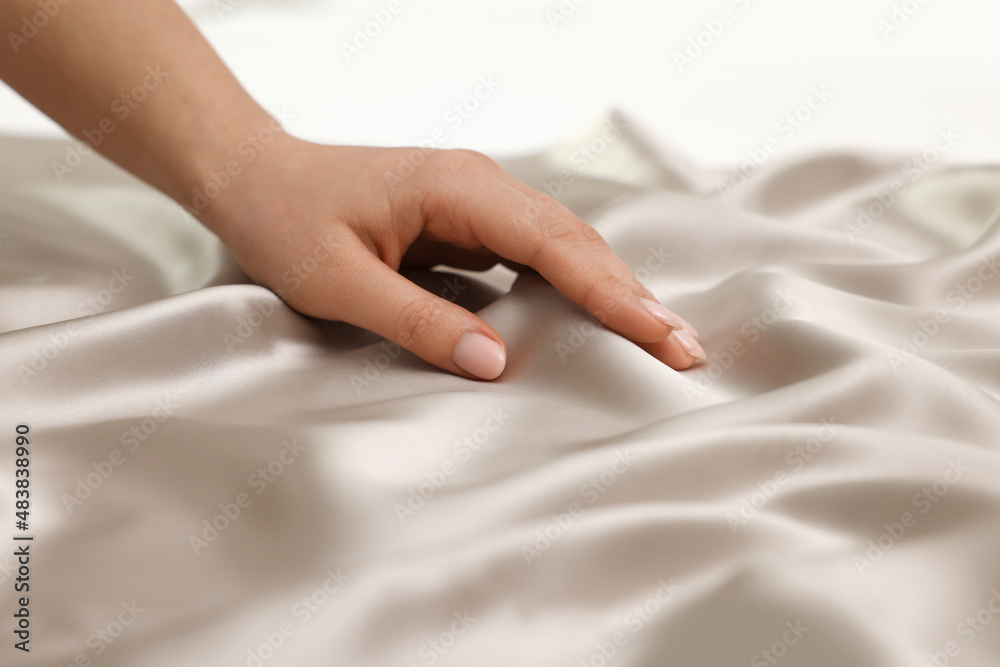 Woman touching smooth silky fabric, closeup view