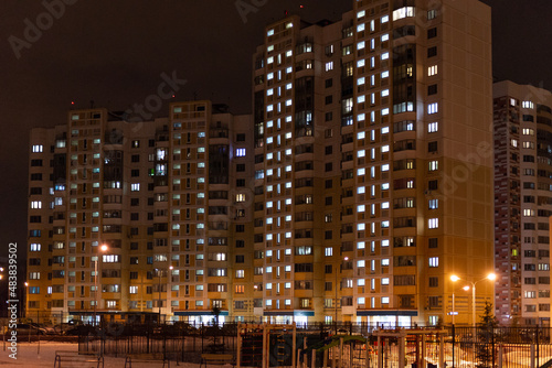 Multi-storey houses night. Windows in apartments glow at night in winter